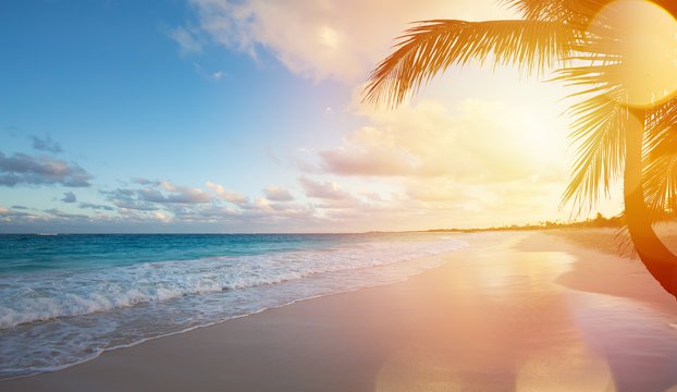 Ocean at sunset with an empty tropical beach
